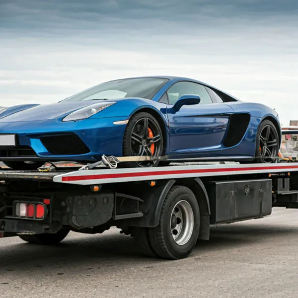 Luxury vehicle securely loaded on a specialized flatbed tow truck for damage-free transport